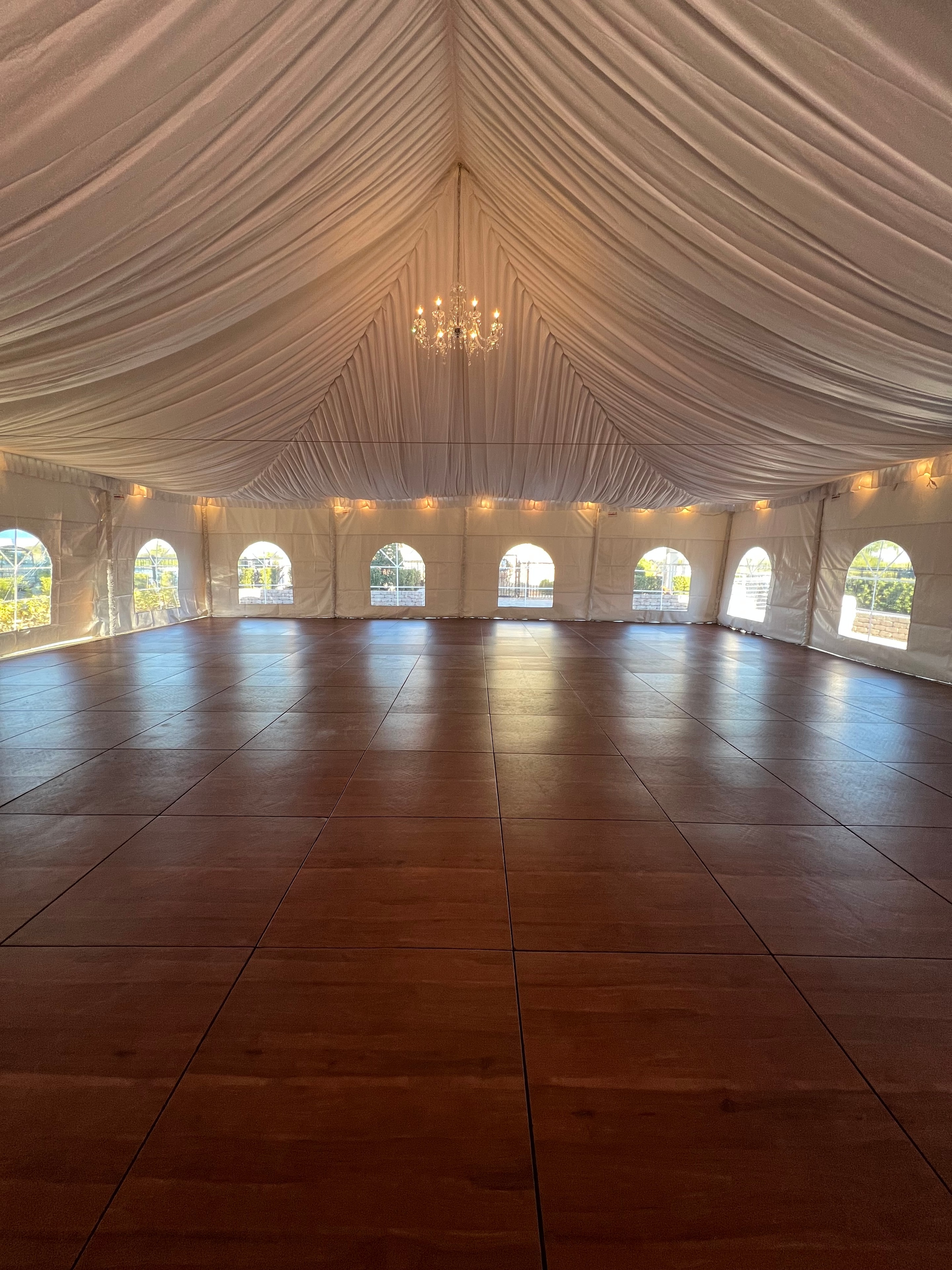 Elegant outdoor tent with chandeliers and draped columns